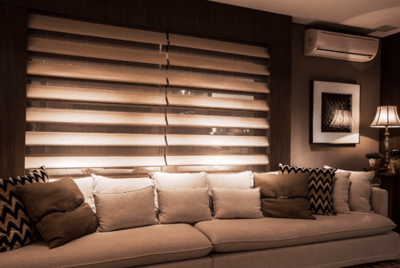 Cortinas de faixas alternadas em tons de marrom atrás de um sofá